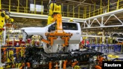 Robots swing a cab and bed into place for a new heavy duty pickup truck on the assembly line where Chevrolet Silverado trucks are being built at General Motors Flint Assembly in Flint, Michigan, Jan. 30, 2019. 