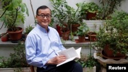 រូបឯកសារ៖ លោក សម រង្ស៊ី អតីត​ប្រធាន​គណបក្ស​សង្គ្រោះ​ជាតិ (CNRP) ដែល​ត្រូវ​បាន​តុលាការ​រំលាយ​ចោល ដែល​កំពុង​រស់នៅ​ភៀសខ្លួន​ក្នុង​ប្រទេស​បារាំង អង្គុយ​នៅ​រានហាល​នៃ​គេហដ្ឋាន​របស់​លោក​ក្នុង​ប្រទេស​បារាំង​នៅ​ថ្ងៃទី ១៩ ខែកក្កដា ឆ្នាំ២០១៨។ (REUTERS/Philippe Wojazer)