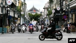 រូបឯកសារ៖ អ្នកជិះម៉ូតូពាក់ម៉ាស់នៅលើផ្លូវកាត់មួយក្នុងក្រុងហាណូយ កាលពីថ្ងៃទី២៣ ខែមេសា ឆ្នាំ២០២០។