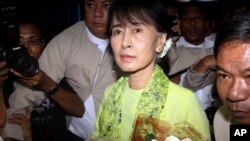 Burmese opposition leader Aung San Suu Kyi, center, arrives at Rangoon International airport to leave for United State Sunday, Sept . 16 2012, in Yangon.