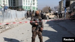 FILE - An Afghan security officer stands guard at the site of a bomb blast in Kabul, Afghanistan, Dec. 15, 2020. Another explosion on Dec. 18, 2020, killed at least 15 civilians in eastern Ghazni province, Afghan officials reported. 