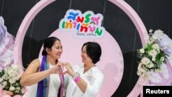 คู่รัก LGBTQ+ โพสท่าถ่ายรูปหลังจากได้รับทะเบียนสมรสอย่างเป็นทางการ ในขณะที่ร่างพระราชบัญญัติความเท่าเทียมในการแต่งงานของประเทศไทยมีผลบังคับใช้ ในกรุงเทพฯ 23 ม.ค. 2025 (Reuters)