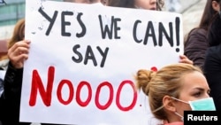 Demonstrators wear masks during a protest against the dismantling of Syria's chemical weapons in Albania, in front of the U.S. embassy in Tirana, November 12, 2013. 