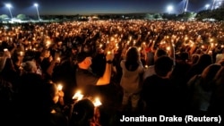 FILE - People attend a candlelight vigil the day after a shooting at Marjory Stoneman Douglas High School in Parkland, Florida, U.S., February 15, 2018. 