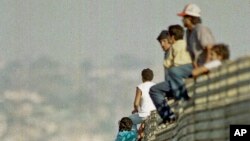 ARSIP – Foto yang diambil tanggal 14 Oktober 1991 ini memperlihatkan sekelompok imigran Meksiko melompati pagar perbatasan untuk memasuki Amerika Serikat, dekat Tijuana, Meksiko (foto: AP Photo/Lenny Ignelzi)