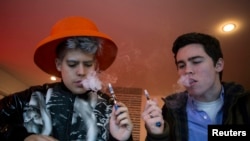 Para pelanggan mengepulkan uap dari rokok elektronik di Henley Vaporium di New York City (foto: REUTERS/Mike Segar)
