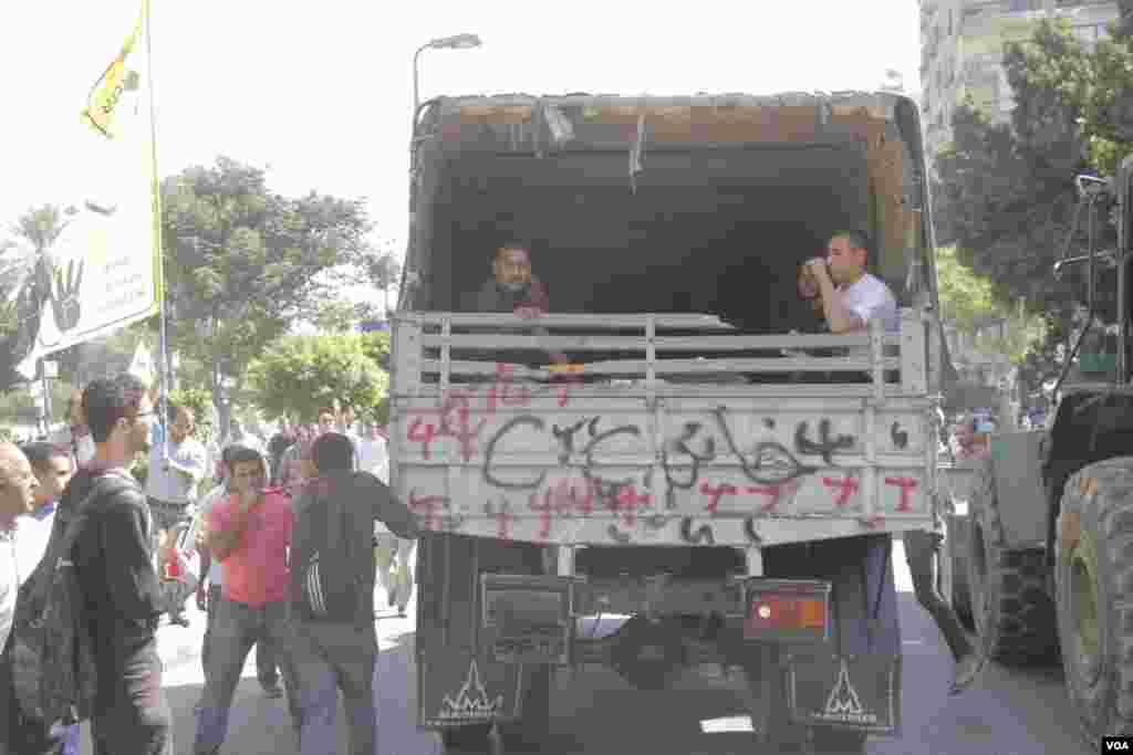 A military vehicle drives through an anti-coup protest in Nasr City, Cairo, Oct. 11, 2013. (Hamada Elrasam for VOA)