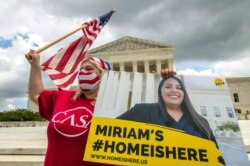 Ivania Castillo from Prince William County, Va., holds a banner to show her support for dreamer Miriam from California, June 18, 2020, in Washington.