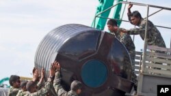 Anggota militer Maladewa mengangkat tangki air ke sebuah kendaraan militer untuk diisi dengan air di Male', 5 Desember 2014.
