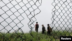 HK URBEX members are seen through a hole in the fence at an abandoned British army barracks in Hong Kong, China, June 1, 2017. 