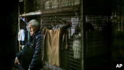 Yeung Ying Biu, 77, duduk dalam tempat tinggalnya, 'kandang' berukuran 1,5 meter persegi di sebuah bangunan kumuh di Hong Kong. (AP/Vincent Yu)