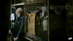 In this Jan. 25, 2013 photo, 77-year-old Yeung Ying Biu sits inside his 1.5 square meter (16 square feet) cage, which he calls home, in Hong Kong. 