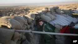 A Kurdish peshmerga fighter pauses during an operation to retake the northern Iraqi town of Sinjar, Nov. 12, 2015. 