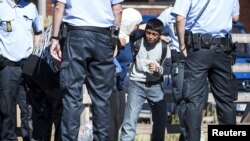 ក្មេង​ប្រុស​ជន​ចំណាក​ស្រុក​ព្យាយាម​រារាំង​ម្តាយ​របស់​ខ្លួន​មិន​ឲ្យ​ចេញពី​រថភ្លើង​ចូល​ទៅ​ក្នុង​ឡាន​នៅ​ឯ​ស្ថានីយ៍​រថភ្លើង​ Rodby នៅភាគខាង​លិច​នៃ​ប្រទេស​ដាណឺម៉ាក កាលពីថ្ងៃទី៩ ខែកញ្ញា ឆ្នាំ២០១៥។