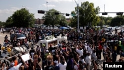 People gather as the horse-drawn carriage carrying the casket containing the body of George Floyd, passes by on its way to Houston Memorial Gardens cemetery in Pearland, Texas, June 9, 2020. 