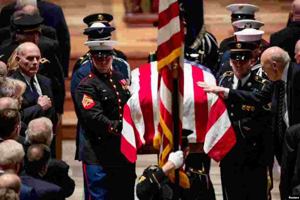 Former Sen. Alan Simpson (R-WY) touches the flag-draped casket of former President George H.W. Bush as it is carried out by a military honor guard during a State Funeral at the National Cathedral in Washington, Dec. 5, 2018.