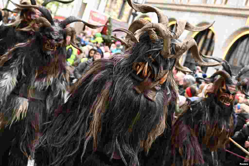 People wearing traditional Krampus costumes and masks attend a traditional parade in Munich, Germany.