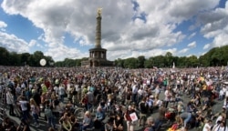 People gather at the Victory Column as they attend a protest rally in Berlin, Germany, Aug. 29, 2020 against new coronavirus restrictions in Germany. Police in Berlin requested thousands of reinforcements from other parts of Germany.