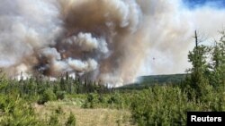 Asap mengepul dari area sungai West Kiskatinaw River dan Peavine Creek saat kebakaran hutan melanda dua wilayah tersebut yang terletak di Dawson Creek Zone, British Columbia, Kanada, pada 7 Juni 2023. (Wildfire Service/Handout via Reuters)