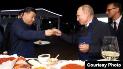 在俄罗斯符拉迪沃斯托克举行的东方经济论坛期间，中国国家主席习近平(左)和俄罗斯总统弗拉基米尔·普京(Vladimir Putin)一边品尝食物，一边敬酒。(2018年9月11日）