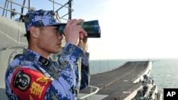 Anggota angkatan laut China melakukan pengawasan dari dek kapal Liaoning, dalam uji coba pelayaran di Laut China Timur. (Foto: Dok)