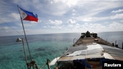 FILE - A Philippine flag flutters from BRP Sierra Madre, a dilapidated Philippine Navy ship that has been aground since 1999 and became a Philippine military detachment on the disputed Second Thomas Shoal in the South China Sea, March 29, 2014.