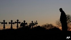 Isaac Hernandez and his wife Crystal (obscured) visit a line of crosses before a vigil for the victims of the First Baptist Church shooting, Nov. 6, 2017, in Sutherland Springs, Texas. 