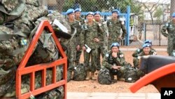 FILE - Japan's Ground Self-Defense Force troop members wait to board a plane as they start leaving South Sudan as part of the process to end their five-year participation in the ongoing U.N. peacekeeping mission in the country, April 17, 2017. Poll results released May 29 show that about half of Japan's population supports a constitutional revision that would clarify the legality of the country's military.