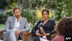 This undated image released March 7, 2021, courtesy of Harpo Productions shows Britain's Prince Harry and his wife, Meghan, Duchess of Sussex, in a conversation with US television host Oprah Winfrey. 