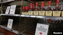 Empty shelves remain with signs ''Buy Canadian Instead'' after the top five U.S. liquor brands were removed from sale at a B.C. Liquor Store, in Vancouver