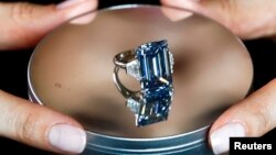 A Christie's employee poses with the 14.62 carats Oppenheimer Blue diamond during a preview in Geneva, Switzerland May 12, 2016. 