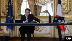 FILE - French President Emmanuel Macron conducts a phone call in his office at the Elysee Palace in Paris, France, on April 21, 2020. 