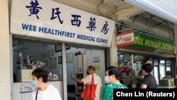 Orang-orang mengantre untuk menanyakan vaksin Sinovac di sebuah klinik, selama wabah COVID-19 di Singapura, 18 Juni 2021. (Foto: REUTERS/Chen Lin)