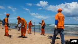 Municipality workers clean oil at a beach in Lauro de Freitas, Bahia state, Brazil, on November 2, 2019.