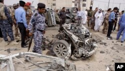 Pasukan keamanan Irak memeriksa lokasi serangan bom mobil di Basra, Minggu (17/3). 