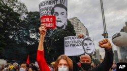 Demonstranti drže transparente sa porukom: "Opoziv odmah! Uhapsiti Bolsonara" na protestu protiv brazilskog predsednika u Sao Paolu, 19. juna 2021. 