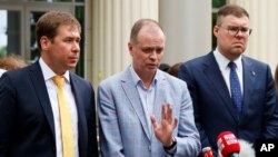 Russian lawyer Ivan Pavlov, center, speaks to the media as lawyers Ilya Novikov (L) and Vladimir Voronin (R) listen in front of Moscow Court in Moscow, June 9, 2021. A court is expected to outlaw the organizations founded by opposition leader Navalny.
