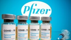 FILE PHOTO: Vials and medical syringe are seen in front of Pfizer logo in this illustration