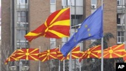 FILE - Macedonian and European flags fly side by side in Macedonia's capital Skopje, March 15, 2012.