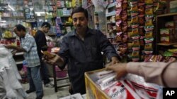 Ashwani Dang, owner of a mom and pop store, bargains with a customer at Karol Bagh market in New Delhi, India, November 24, 2011.