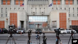 FILE - Media outlets set up cameras outside a detention center in New York, July 14, 2020.