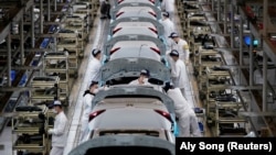 Employees work on a production line inside a Dongfeng Honda factory after lockdown measures in Wuhan, China's center of the novel coronavirus disease (COVID-19) outbreak, were further eased, April 8, 2020. (REUTERS/Aly Song)