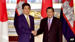 Cambodian Prime Minister Hun Sen, right, poses with his Japanese counterpart Shinzo Abe prior to their meeting at the state guesthouse in Tokyo Monday, Aug. 7, 2017. Hun Sen is on a four-day official visit to Japan. (Toshifumi Kitamura/Pool Photo via AP)