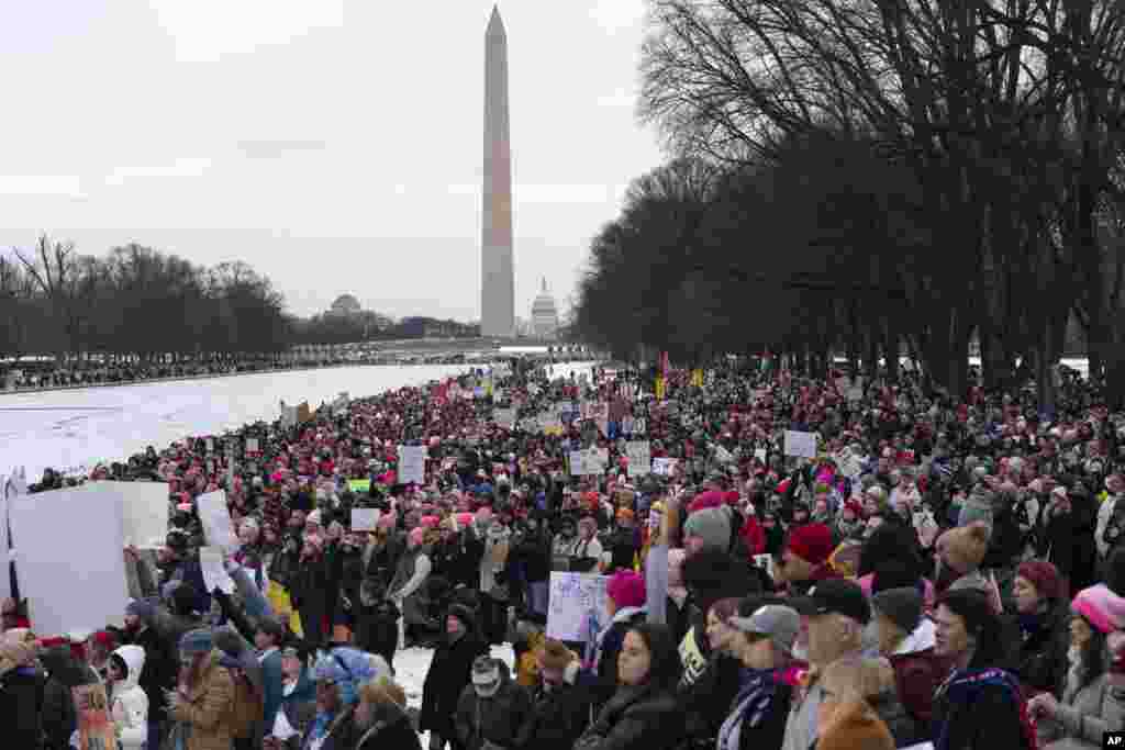 With the Washington Monument in the background, demonstrators protest President-elect Donald Trump's incoming administration at the Lincoln Memorial during the People's March, Jan. 18, 2025, in Washington. 