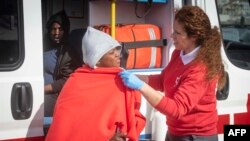 Seorang pengungsi menerima bantuan dari anggota Palang Merah Spanyol setibanya di kapal penjaga perairan Spanyol di pelabuhan Tarifa, 14 Juni 2018. Hundreds of migrants including minors and pregnant women have been rescued in the waters of the Strait of G