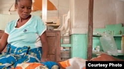 Antho watches over her son Kaba, two, who is being treated for cerebral malaria at the Tshilundu Referral Hospital in Kasai Oriental Province, DRC. Kaba is now in a coma. Antho is nine months pregnant. This is her eighth pregnancy; she had two miscarriages and a daughter who died of malaria aged just eleven months because the clinic they took her to was closed when they arrived. This is not unusual: many local clinics in DRC are under equipped and under staffed. (Credit: Ivy Lahon / Save the Children)