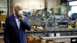 Democratic presidential candidate, former Vice President Joe Biden adjusts his mask during a tour of McGregor Industries, a metal fabricating facility in Dunmore, Pa, July 9, 2020.