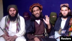 FILE - Omar Khalid Khorasani (C), a top Pakistan Taliban commander, gives an interview in Pakistan's Mohmand tribal region on June 2, 2011.