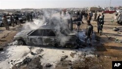 A destroyed car smolders after a bombing in Karbala, 80 kilometers (50 miles) south of Baghdad, Iraq, 20 Jan 2011