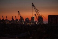 Rows of damaged cranes stand at the site of the Aug. 4 deadly blast in the port of Beirut that killed scores and wounded thousands as the sun sets over the capital Beirut, Lebanon, Aug. 25, 2020.